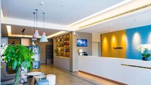A modern hotel reception area with a reception desk, seating area, and a large plant. - Homeinn · neo (Changzhi Medical College) (Changzhi)