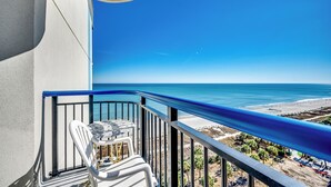 Ein Balkon mit freiem Blick auf Strand und Meer.