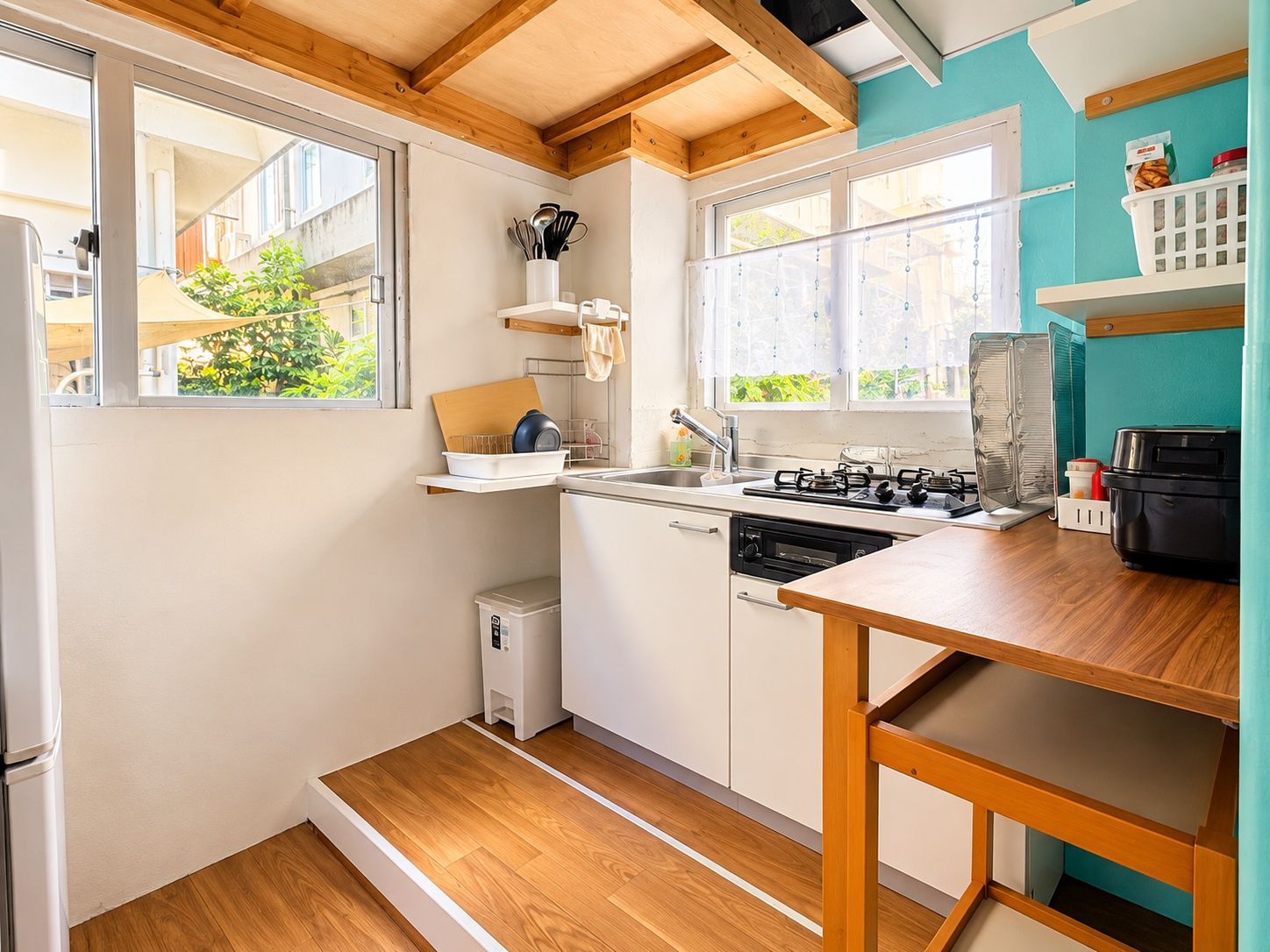 A compact kitchen with a wooden countertop, a stove, and a sink.