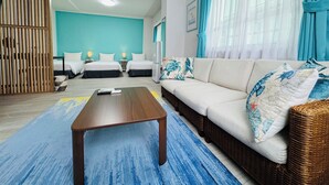 A hotel room with two beds, a sofa, a coffee table, and a large window with curtains. - SimpleStayORIHIME (Ishigaki)