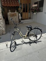 Una bicicleta estacionada frente a un edificio con fachada de piedra y puerta de madera.