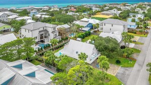 A residential area with houses, a swimming pool, and a view of the ocean. - Mermaid’s Retreat - Heated Private Pool, Walk to Beach, Complimentary Bikes! (Santa Rosa Beach)