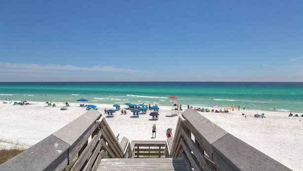 A beach with a wooden boardwalk leading to the shore, featuring umbrellas and beach chairs. - Mermaid’s Retreat - Heated Private Pool, Walk to Beach, Complimentary Bikes! (Santa Rosa Beach)