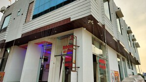 Un hotel con fachada moderna, amplias ventanas y una entrada visible.