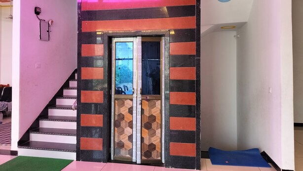 Una escalera conduce a una habitación con una puerta que tiene un diseño geométrico.