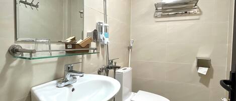 Un baño con lavamanos, inodoro y estante de vidrio.