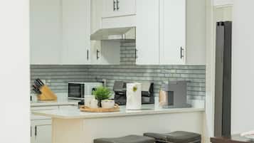 Een koelkast, kookgerei, borden en bestek