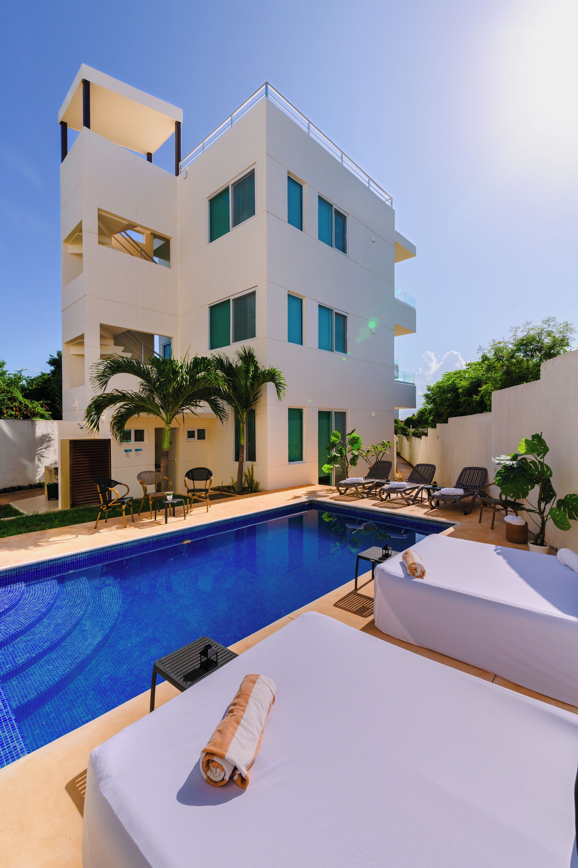 Una piscina al aire libre, sillones reclinables de piscina