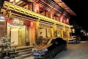 A traditional building with ornate architectural details and a car parked in front. - Shangri-La Yunjianjuju (Shangri-La)