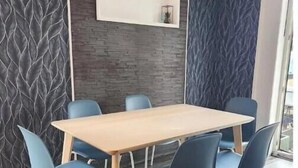 Un espace repas moderne avec une table en bois et six chaises bleues.