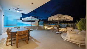 Eine moderne Terrassenanlage mit Pool, Essbereich und Lounge-Möbeln.