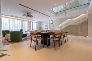 A modern dining area with a round table, six chairs, and a ceiling fan. - Seaside Villa by Brown Hotels (Trogir)