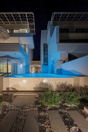 A modern building with a swimming pool, outdoor seating, and a unique architectural design. - Seaside Villa by Brown Hotels (Trogir)