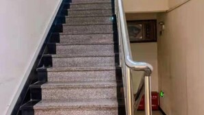A staircase with a handrail, carpeted steps, and a door at the bottom. - Nanwang Hotel (Shanghai Fengxian University Town) (Shanghai)