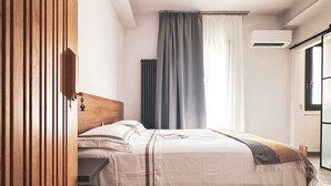A bedroom with a bed, curtains, a window, and a patterned floor. - Dimora Harmonia, authentic charm combined by modern and refined ambience. (Carini)