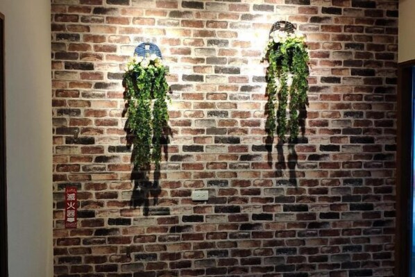 Una pared de ladrillo con dos adornos colgantes verticales.