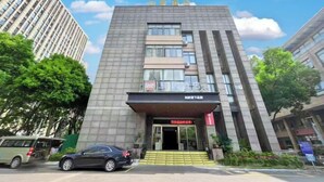 A modern hotel with a prominent entrance, multiple floors, and a clear sky. - Ease Hotel (South Ningbo CBD Romon World Park Store, BTG Homeinns) (Ningbo)