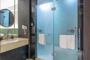 A modern bathroom with a glass shower enclosure, a sink with a mirror, and a towel rack. - Ease Hotel (South Ningbo CBD Romon World Park Store, BTG Homeinns) (Ningbo)