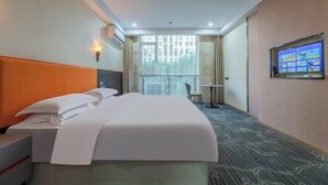 A hotel room with a bed, a desk, a chair, a TV, and a window with curtains. - Ease Hotel (South Ningbo CBD Romon World Park Store, BTG Homeinns) (Ningbo)