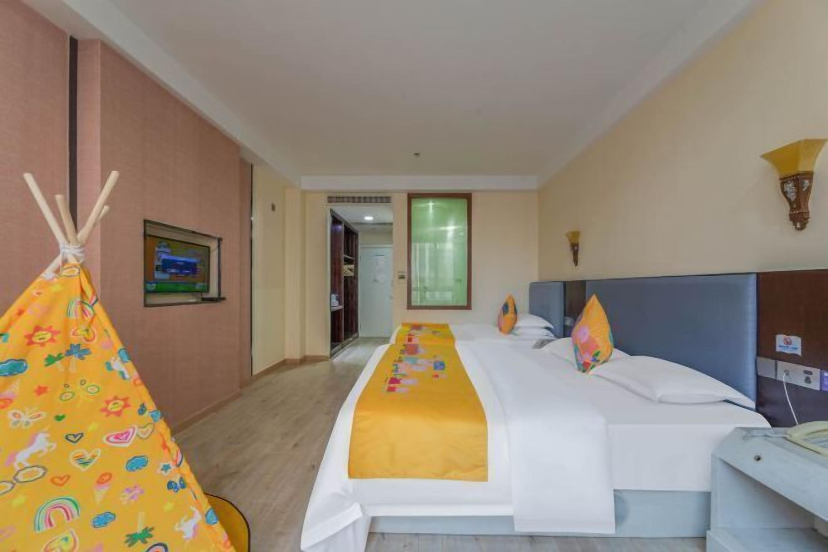 Una habitación de hotel con cama, mesita de noche, silla, ventana y puerta.
