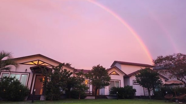 A two-story house with a symmetrical roofline and a central entrance. - GLA Aewol (Jeju City)