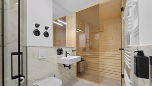 Um banheiro moderno com box de vidro, vaso sanitário branco, pia com torneira preta e lambris de madeira nas paredes.