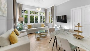 A modern living room with a sofa, coffee table, and dining table.