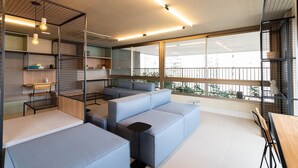 Ein modernes Interieur mit einem Ecksofa, einem kleinen Tisch und einer Sitzecke mit Blick auf die Stadt.