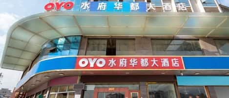 A hotel with a prominent 'OYO' sign, a curved glass facade, and a large entrance.