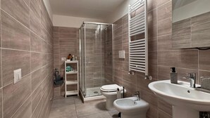A modern bathroom with a glass shower enclosure, a toilet, and a sink. - Mungo in Fiumicino With 1 Bedrooms and 1 Bathrooms (Fiumicino)