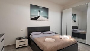 A modern bedroom with a skylight, a large bed, a nightstand, a dresser, and a mirror. - Mungo in Fiumicino With 1 Bedrooms and 1 Bathrooms (Fiumicino)