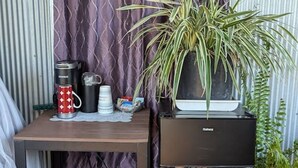 A compact outdoor seating area with a table, a black cabinet, and a potted plant. - Glamping Deck Amazing View! (Oden)
