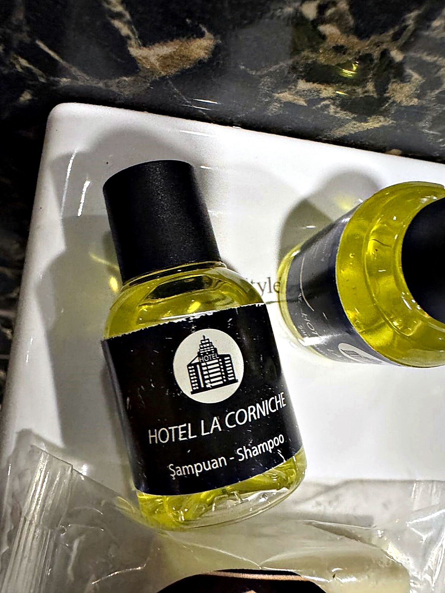 A bottle of Hotel La Corniche shampoo.