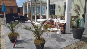 A patio with outdoor furniture, potted plants, and a glass-enclosed area with a view of the house. - 4 BEDROOM COUNTRY HOUSE INDOOR POOL and SAUNA
8 PEOPLE PRIVATE (Saint-Augustin)