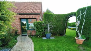 A brick house with a tiled roof, a paved pathway, and a well-maintained lawn. - 4 BEDROOM COUNTRY HOUSE INDOOR POOL and SAUNA
8 PEOPLE PRIVATE (Saint-Augustin)
