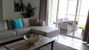 Una sala de estar con un sofá seccional gris, una mesa de centro de madera y una cesta decorativa.