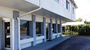Ein Motel mit überdachter Veranda, zahlreichen Fenstern und einem Schild, das Haustiere verbietet.