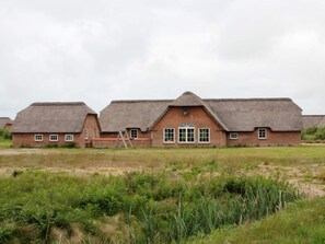 A row of brick buildings with thatched roofs, a central door, and windows. - 4 Star Holiday Home in Ulfborg (Ulfborg)