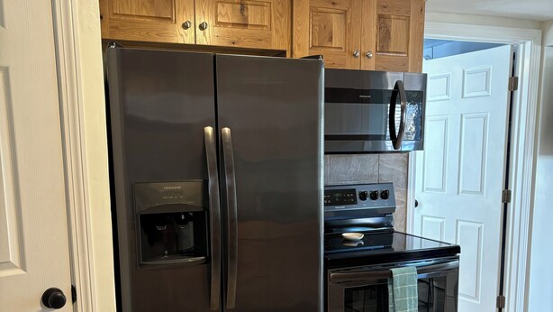 Una cocina con un refrigerador de acero inoxidable, un microondas y un horno.
