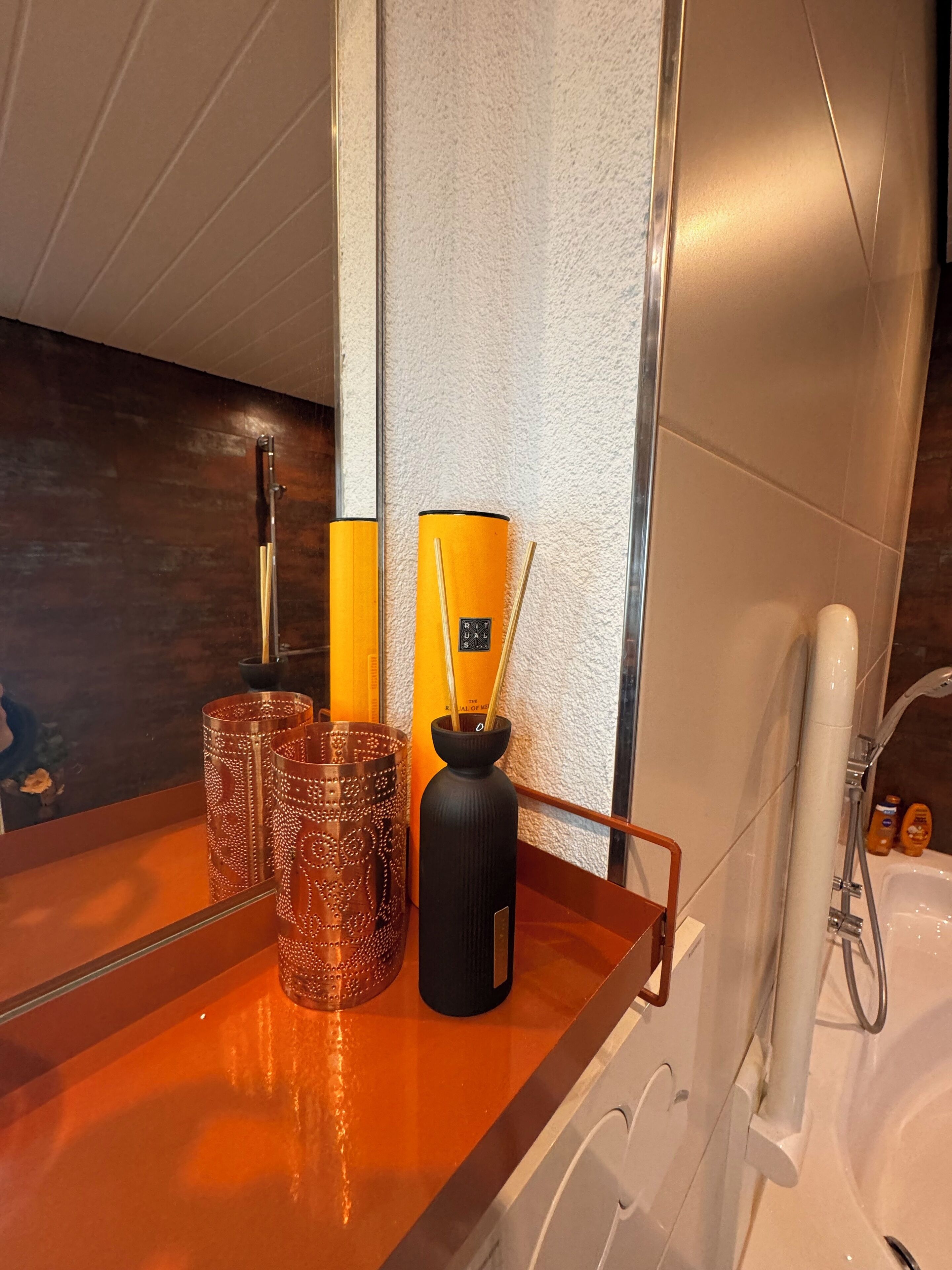 Une salle de bain avec une baignoire, un porte-serviettes et un miroir.