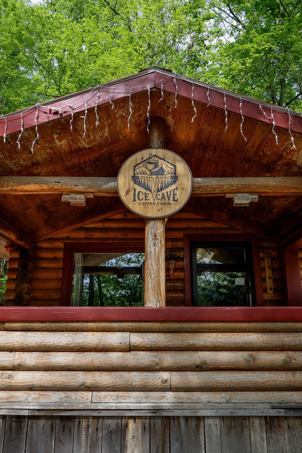 A wooden cabin with a sign reading "ICE CAVE COFFEE CABIN."