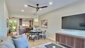 A modern living room with a sofa, coffee table, and a TV mounted on the wall.