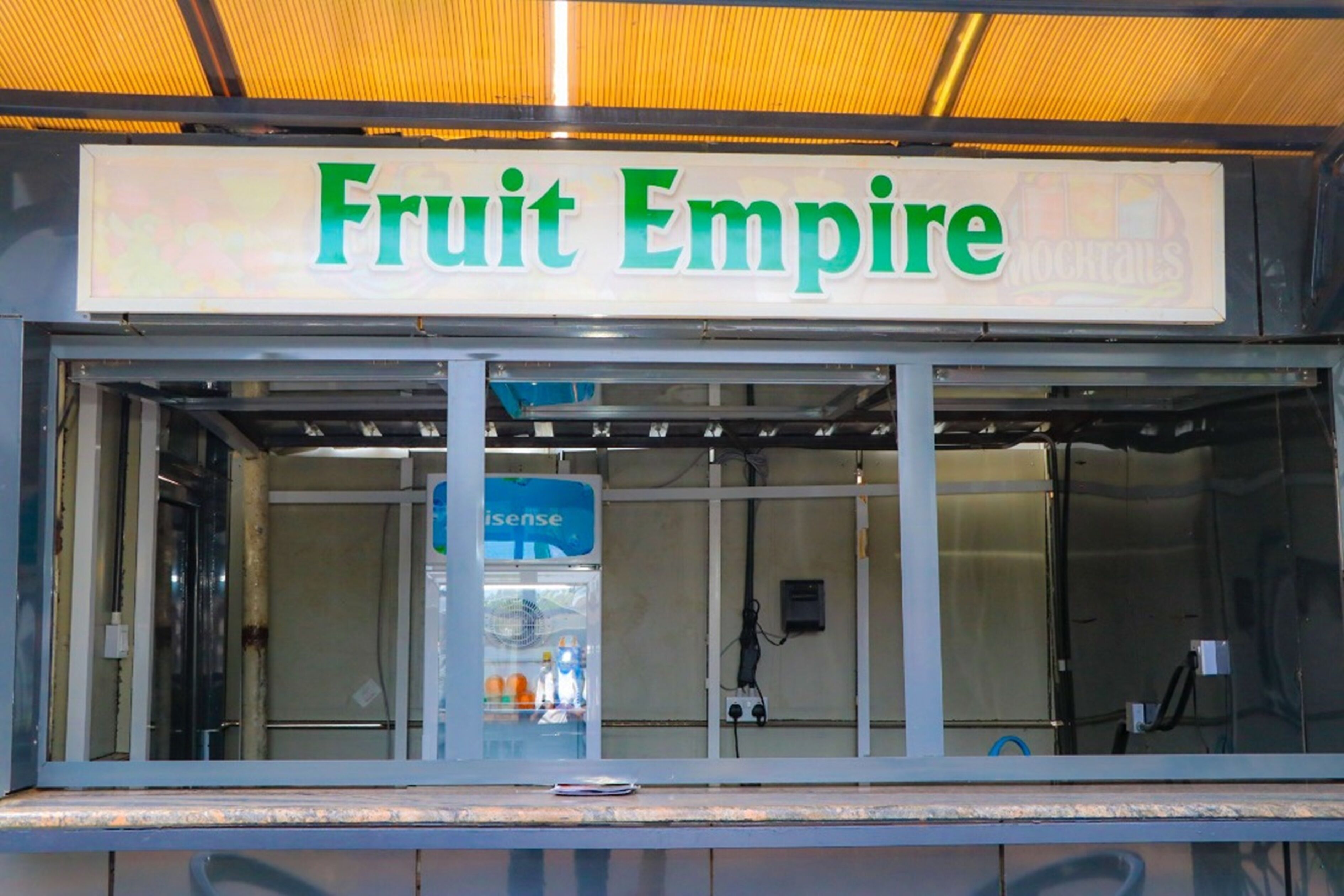 A storefront with a sign reading "Fruit Empire" and a visible blue sign with the word "aisense".