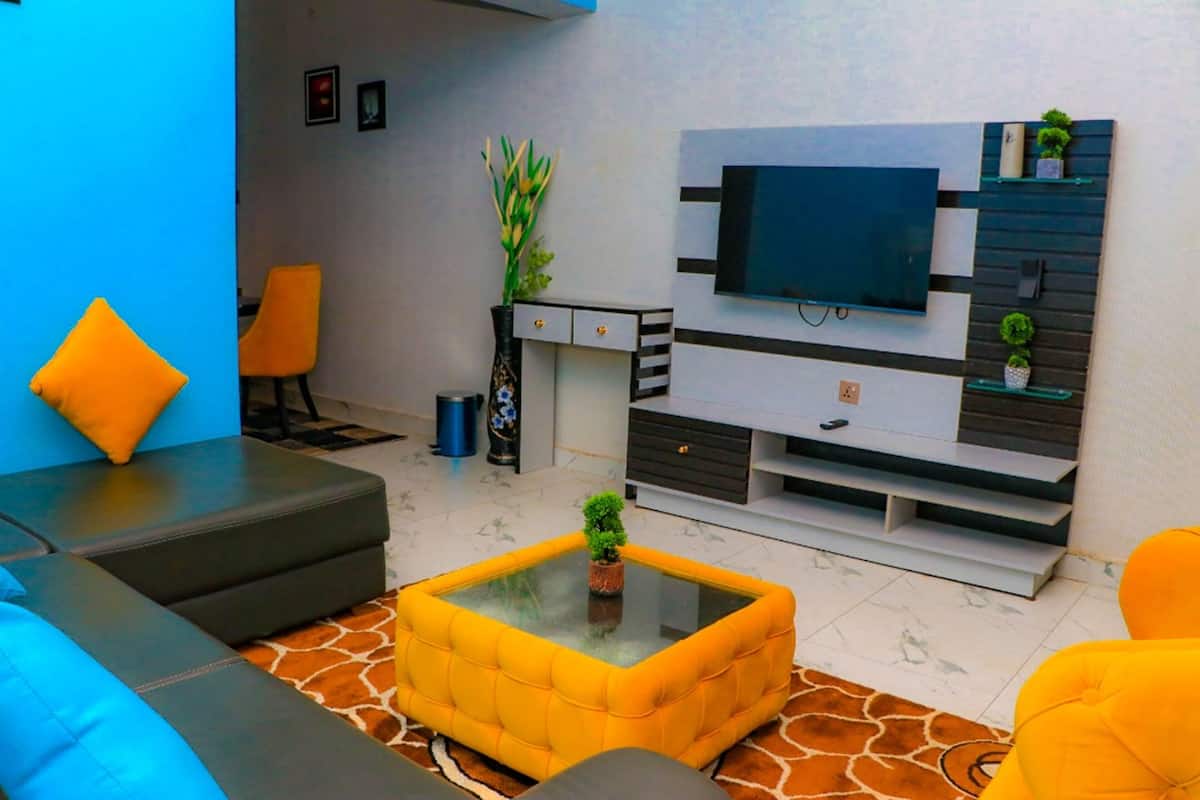 Una sala moderna con sofá, mesa de centro y mueble para televisión.