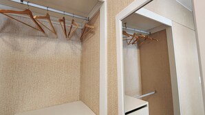 A walk-in closet with wooden hangers on a rod and a mirror on the door. - Beautiful Apartment Miraflores (Miraflores)