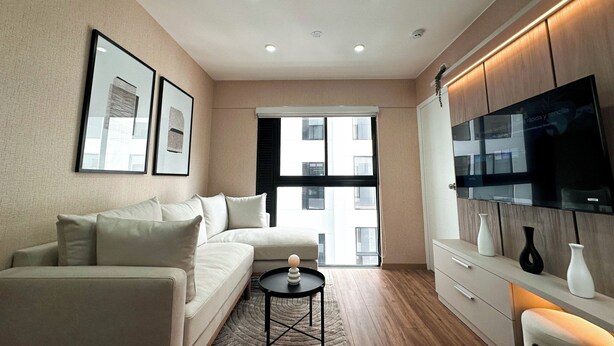 A modern living room with a sofa, coffee table, and a flat-screen TV mounted on the wall. - Beautiful Apartment Miraflores (Miraflores)