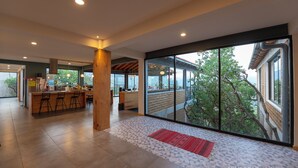 Eine geräumige Küche mit einer zentralen Kochinsel, großen Fenstern mit Blick ins Freie und einem modernen Interieur.