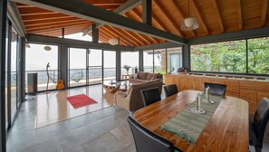 Relax in this inviting living area with a high ceiling, floor-to-ceiling windows, and a comfortable sofa.