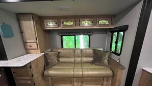 Ein gemütliches Wohnmobil-Interieur mit einer Sitzecke, einem kleinen Tisch und einem Schrank.