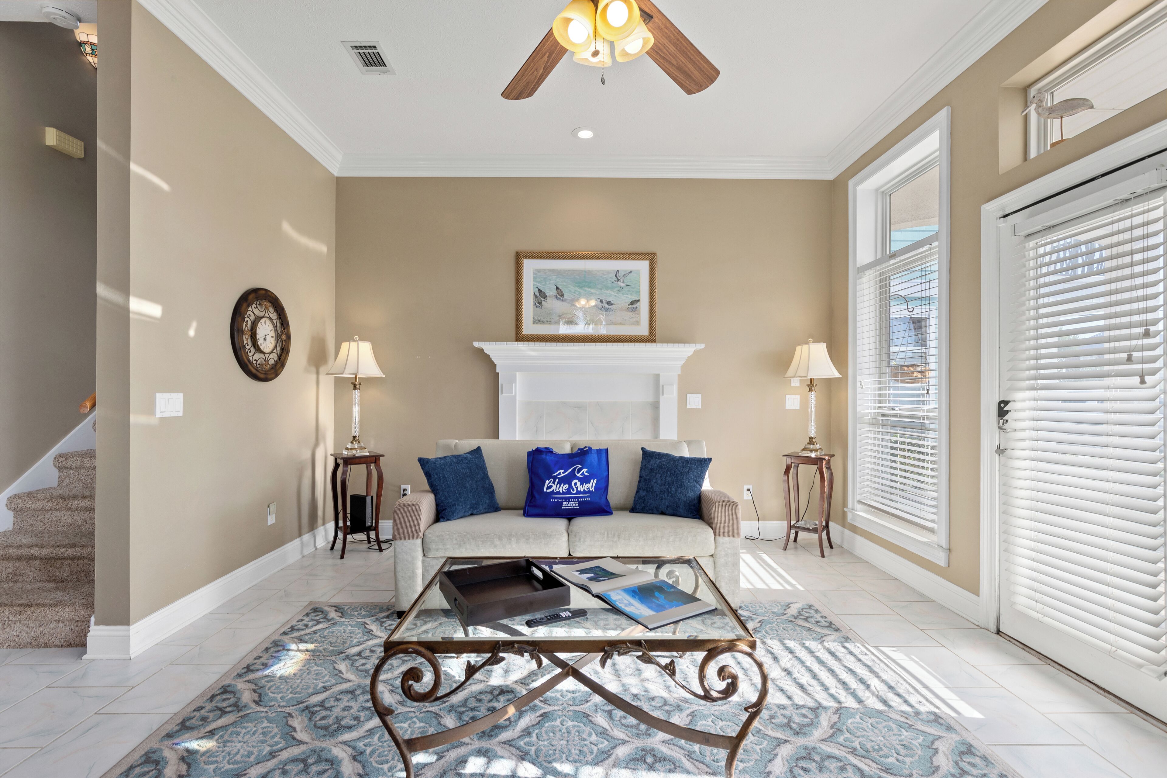 A living room with a beige wall, a white fireplace, a blue sofa, and a coffee table.